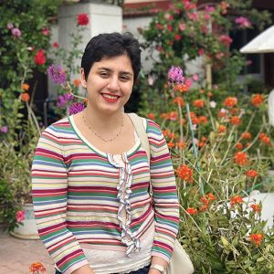 Alaleh Azhir poses in front of flowers.