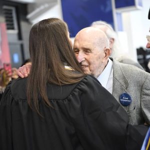 Seymour Baron hugs his granddaughter with a "proud grandparent" pin.