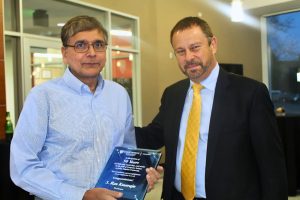 S. Rao Kosaraju and Dean Ed Schlesinger at a 2019 reception honoring Kosaraju's 50 years in the Department of Computer Science. Kosaraju holds a plaque denoting this honor.