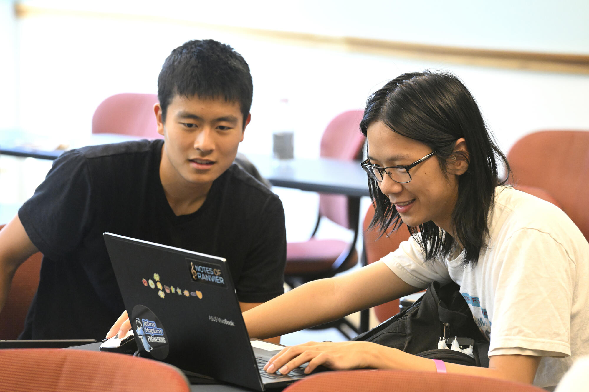 Two students look at a laptop during HopHacks.