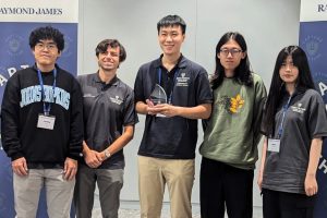 The Johns Hopkins University team at the competition. One student holds a trophy.