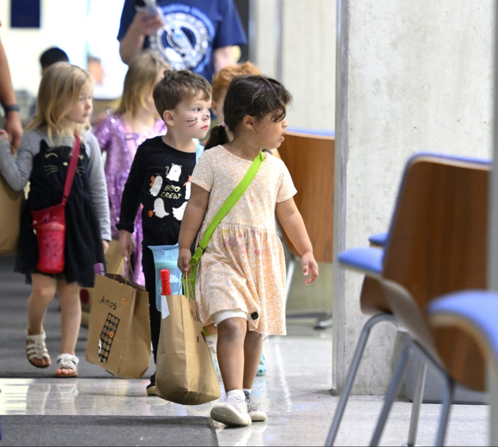 Trick-or-treaters walk through Malone Hall.