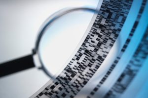 A magnifying glass over a DNA sequence.