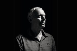 A black-and-white portrait of Alan Yuille in shadow with a spotlight on half of his face.