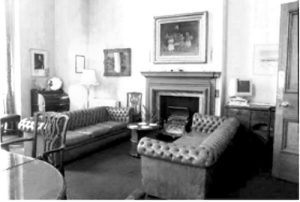 Black-and-white image of a living room with furniture including couches and a fireplace.