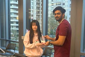 Xinyue Huang receives an award from a man wearing a lanyard.